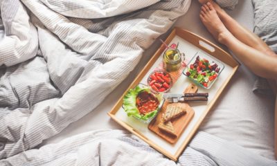 woman lying on bed with breakfast tray