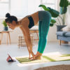 Shot of a young woman using a digital tablet while practicing yoga at home