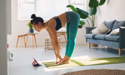 Shot of a young woman using a digital tablet while practicing yoga at home
