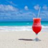 iced cocktail on the beach with blue skies