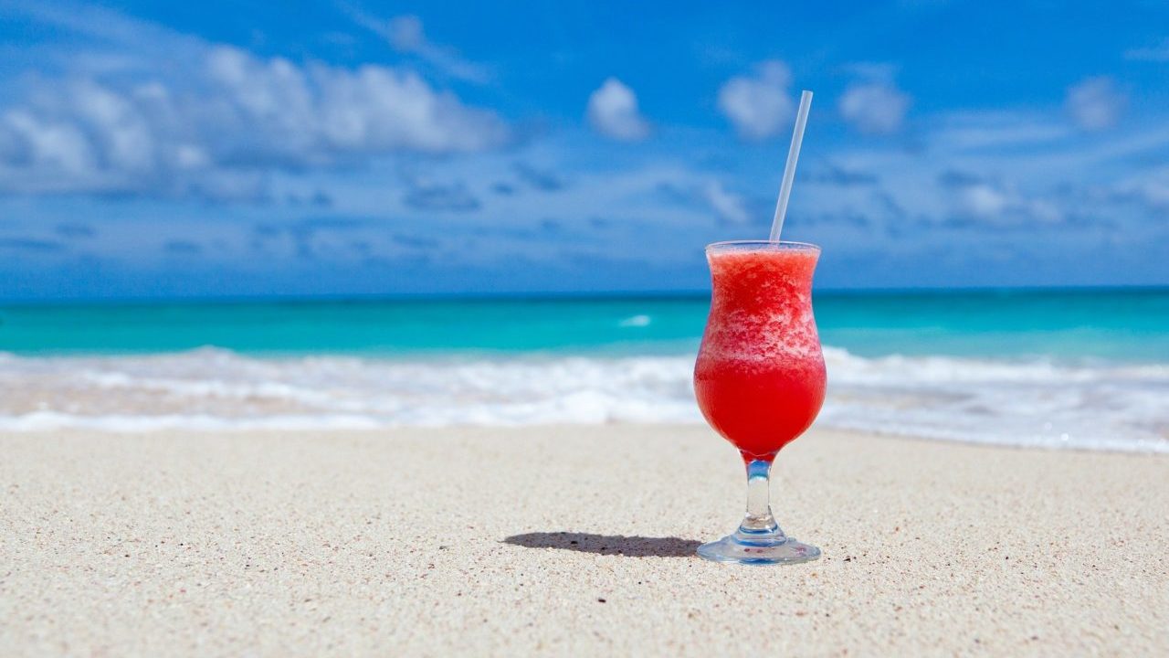 iced cocktail on the beach with blue skies