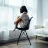 woman sitting on chair staring out the window