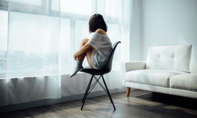 woman sitting on chair staring out the window