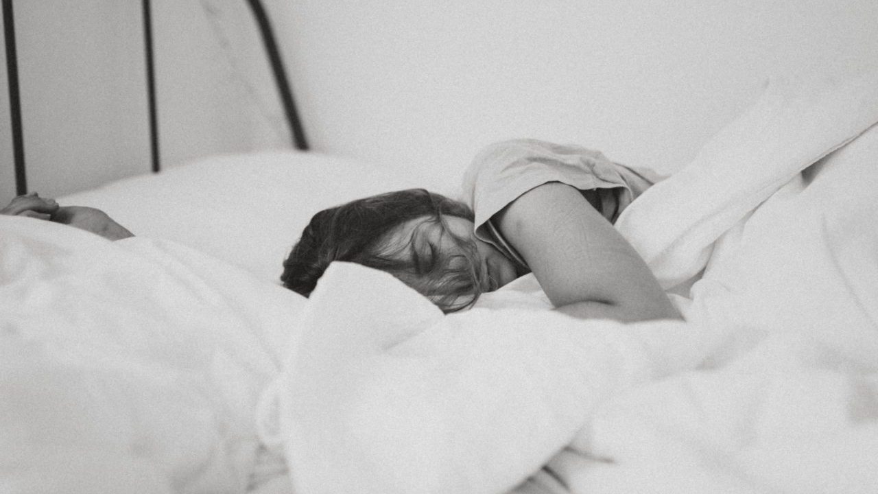 black and white image of woman sleeping in bed