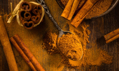 Cinnamon powder in vintage spoon with cinnamon sticks