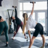 Athletic ladies exercising with dumbbells at morning gym class